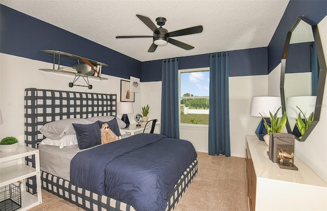 bedroom with ceiling fan, light carpet, and a textured ceiling