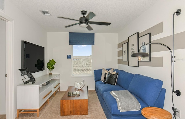 carpeted living room with a textured ceiling and ceiling fan