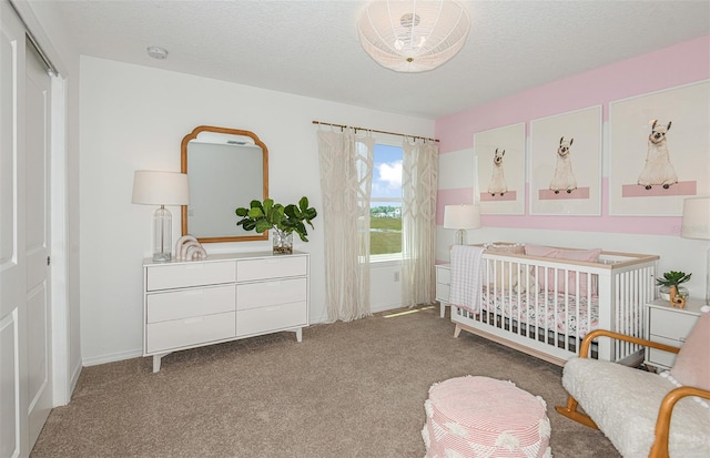 bedroom with a textured ceiling, carpet floors, a closet, and a nursery area