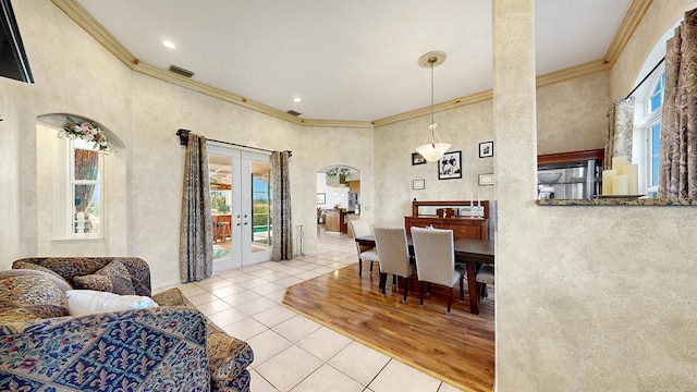 dining space featuring french doors, crown molding, and light hardwood / wood-style flooring