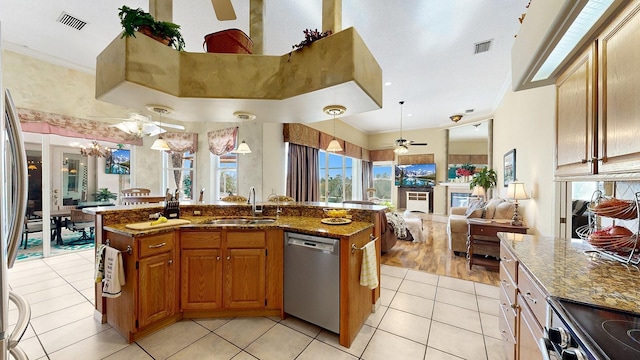 kitchen with sink, a center island with sink, dark stone counters, and appliances with stainless steel finishes