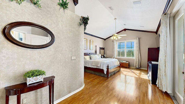 bedroom with lofted ceiling, crown molding, ceiling fan, light wood-type flooring, and a textured ceiling