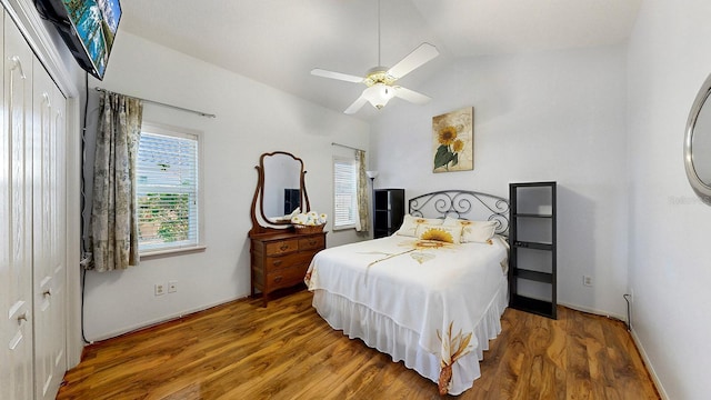 bedroom with ceiling fan, a closet, wood-type flooring, and vaulted ceiling