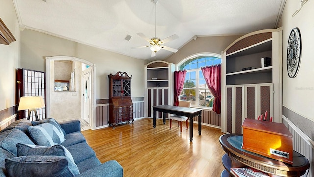 living room featuring lofted ceiling, crown molding, ceiling fan, a textured ceiling, and light hardwood / wood-style floors