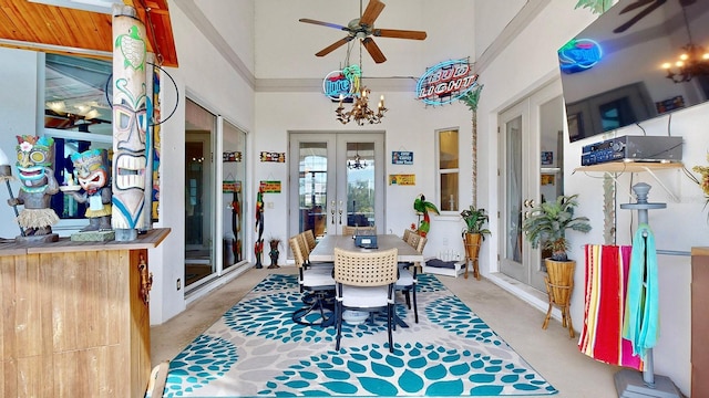 sunroom featuring french doors and ceiling fan with notable chandelier