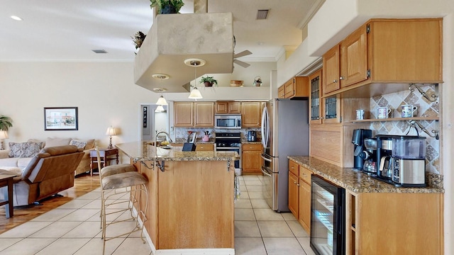 kitchen featuring stainless steel appliances, beverage cooler, backsplash, crown molding, and decorative light fixtures