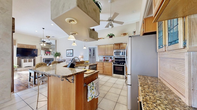 kitchen with pendant lighting, a breakfast bar, sink, light tile patterned floors, and appliances with stainless steel finishes