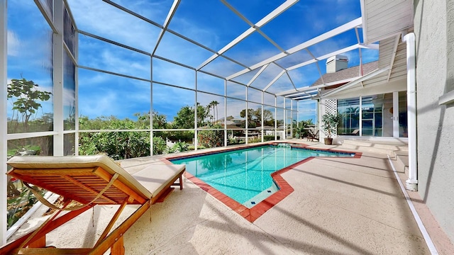 view of pool featuring glass enclosure and a patio