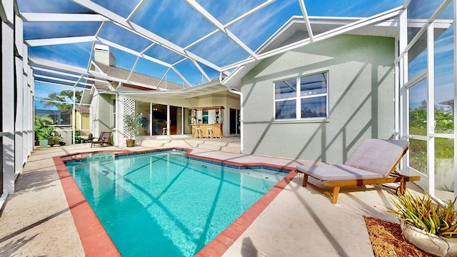 view of pool with a patio, an outdoor bar, and a lanai