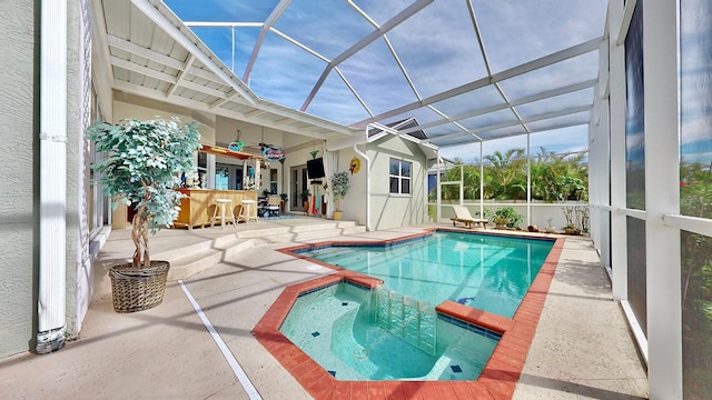 view of swimming pool featuring a bar, glass enclosure, ceiling fan, and a patio area