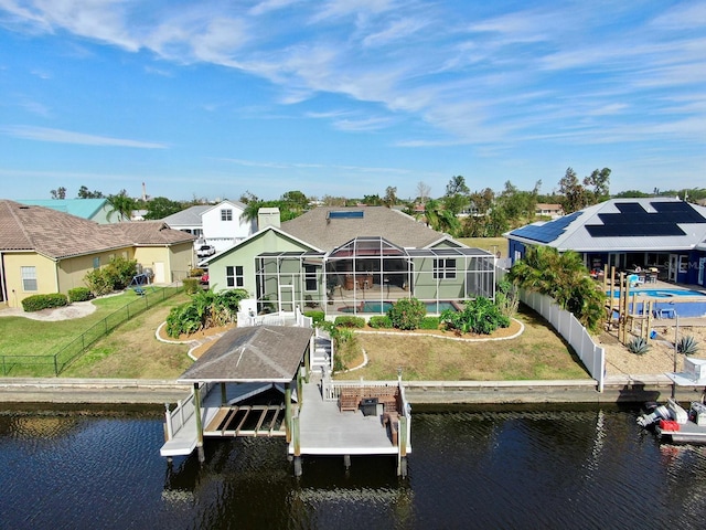 dock area featuring a water view, a lanai, and a lawn