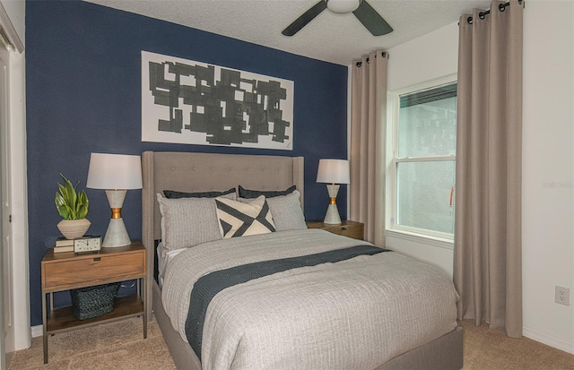 bedroom with ceiling fan, carpet floors, and a textured ceiling