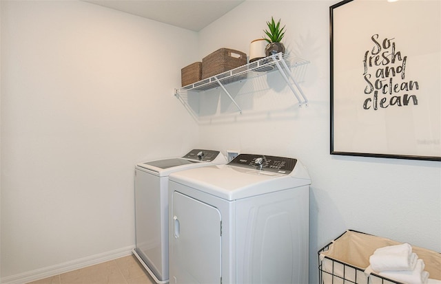 clothes washing area featuring washer and dryer and light tile patterned flooring