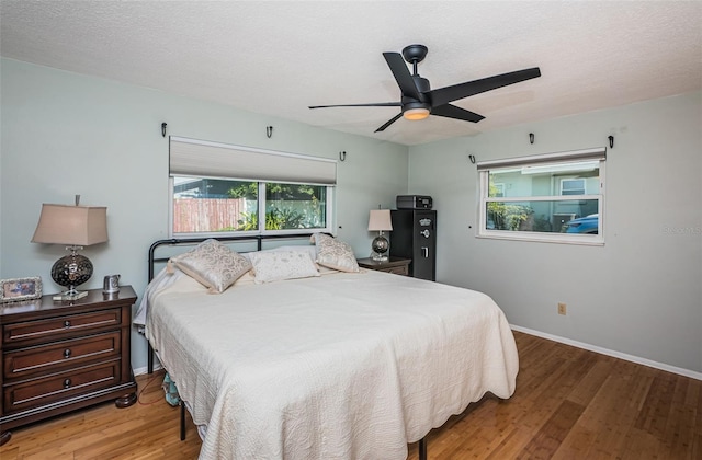 bedroom with hardwood / wood-style floors, a textured ceiling, and ceiling fan