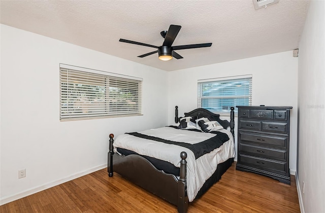 bedroom with hardwood / wood-style flooring, ceiling fan, and a textured ceiling