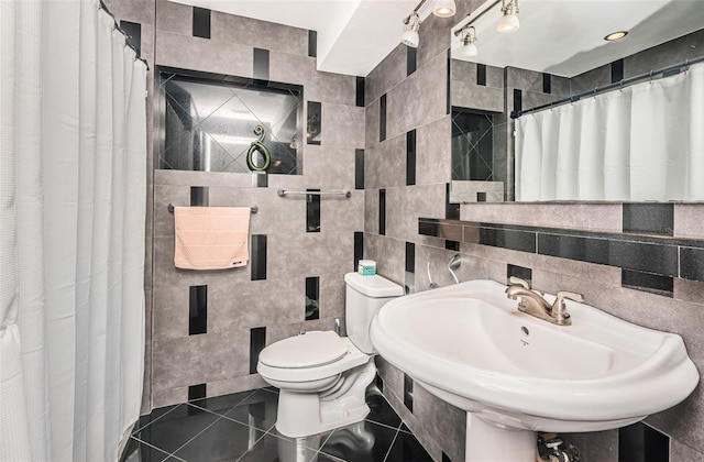 bathroom with sink, tile patterned flooring, toilet, decorative backsplash, and tile walls