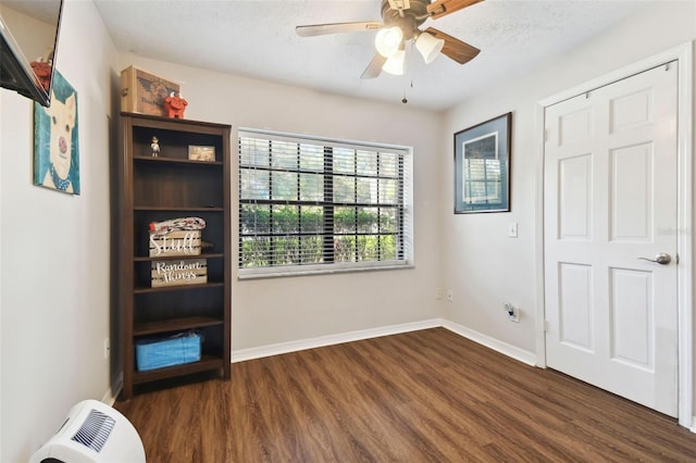 interior space with ceiling fan, dark hardwood / wood-style flooring, and a textured ceiling