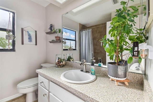 bathroom with a shower with shower curtain, vanity, and toilet