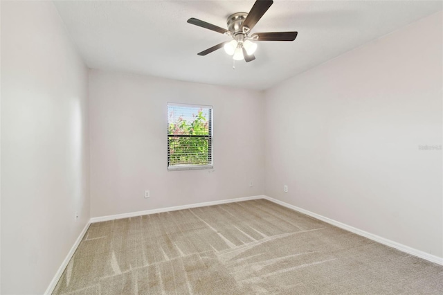 spare room featuring ceiling fan and light colored carpet