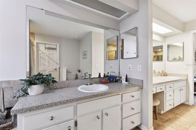 bathroom featuring tile patterned floors, vanity, and toilet