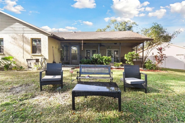 back of house with a sunroom and a lawn