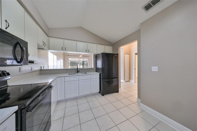 kitchen featuring sink, black appliances, light tile patterned floors, white cabinetry, and lofted ceiling