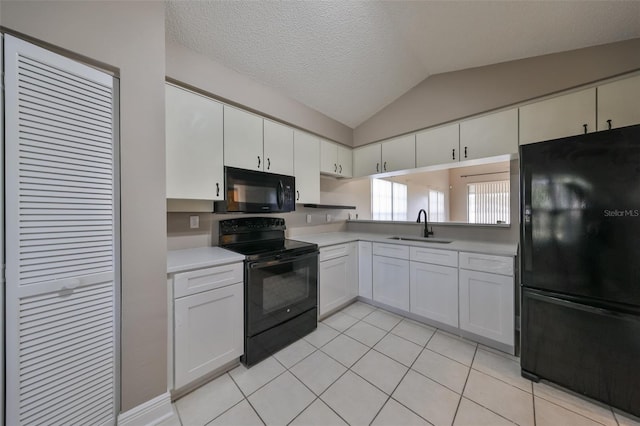 kitchen featuring black appliances, lofted ceiling, white cabinetry, and sink