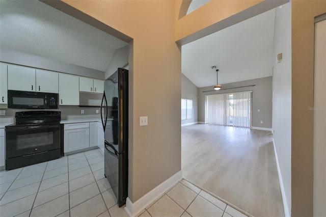 kitchen featuring black appliances, white cabinets, a textured ceiling, and vaulted ceiling