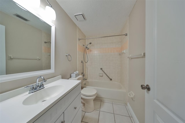 full bathroom with tile patterned floors, vanity, a textured ceiling, tiled shower / bath combo, and toilet