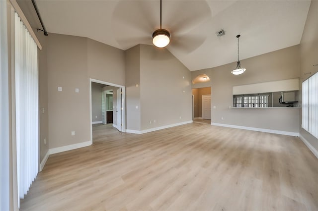 unfurnished living room with ceiling fan, light wood-type flooring, and high vaulted ceiling