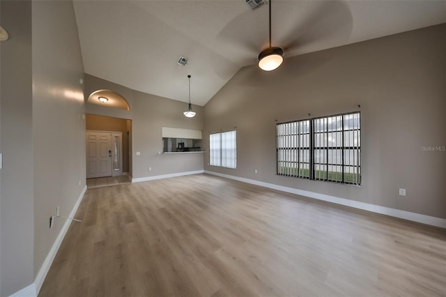 unfurnished living room with light hardwood / wood-style flooring, high vaulted ceiling, and ceiling fan