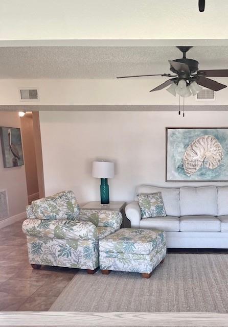 living room with tile patterned floors and ceiling fan