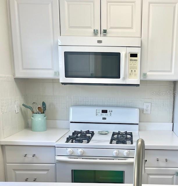 kitchen with white cabinets, white appliances, and backsplash