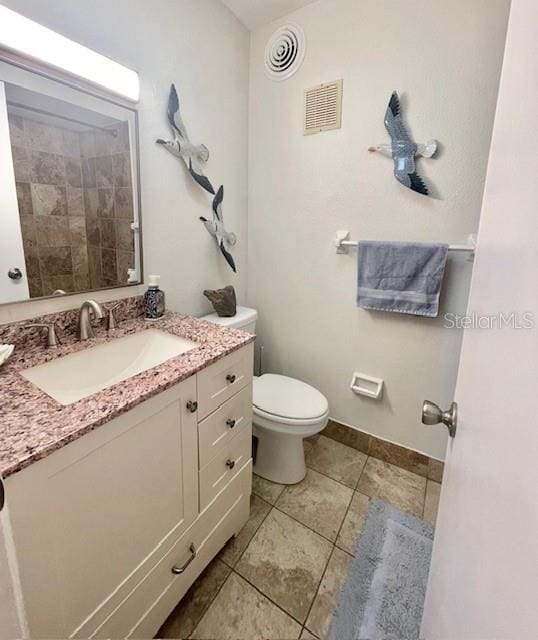 bathroom featuring tile patterned floors, vanity, and toilet