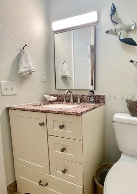 bathroom featuring vanity and toilet