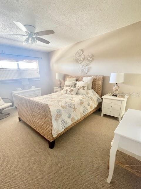 carpeted bedroom featuring ceiling fan and a textured ceiling