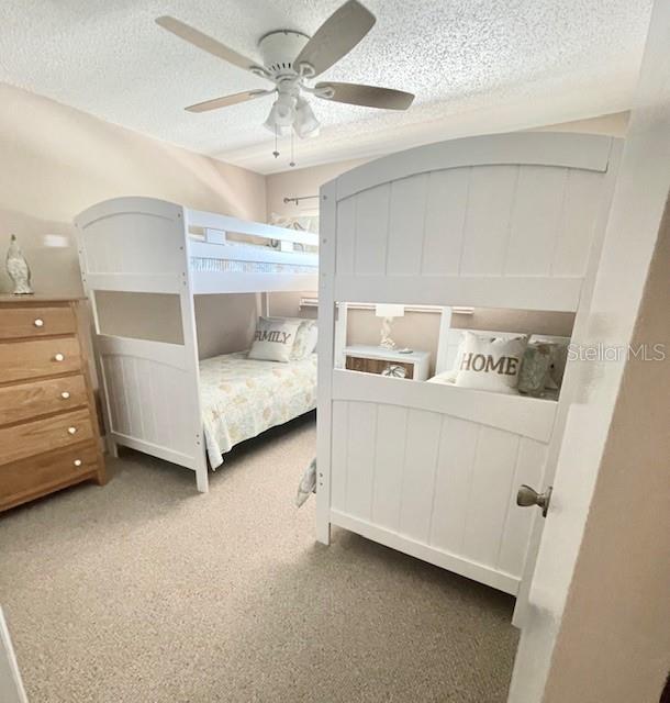 bedroom with ceiling fan and a textured ceiling