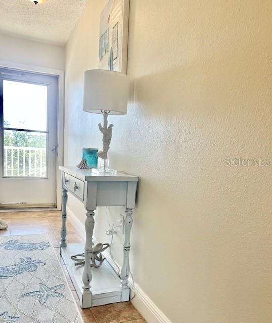 doorway to outside with light tile patterned floors and a textured ceiling