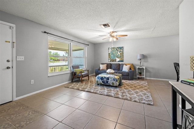 tiled living room featuring ceiling fan and a textured ceiling