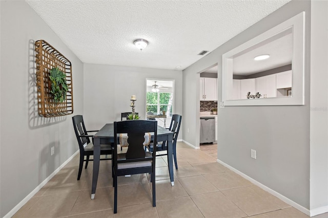 tiled dining room featuring a textured ceiling and ceiling fan