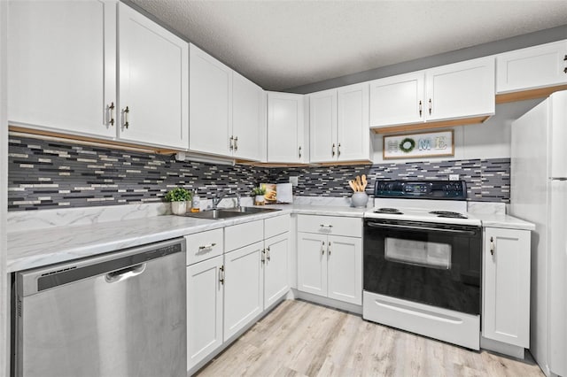 kitchen with a textured ceiling, white appliances, sink, white cabinets, and light hardwood / wood-style floors