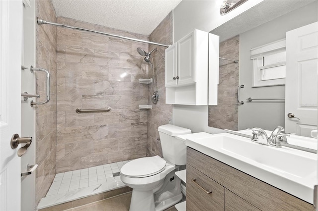 bathroom featuring tile patterned floors, a tile shower, vanity, a textured ceiling, and toilet