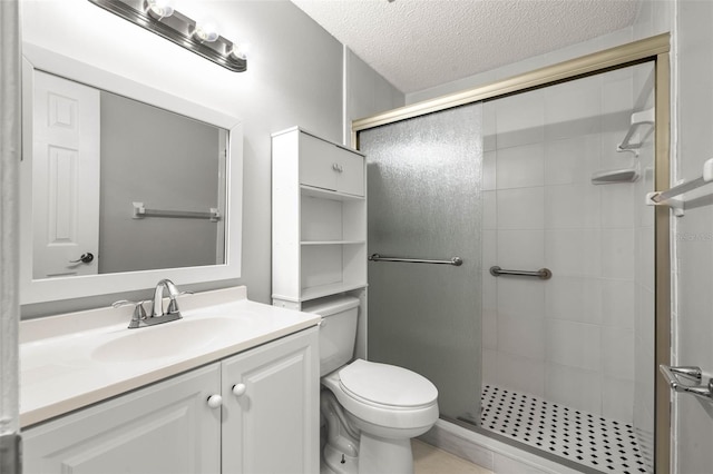 bathroom featuring vanity, a shower with shower door, a textured ceiling, and toilet