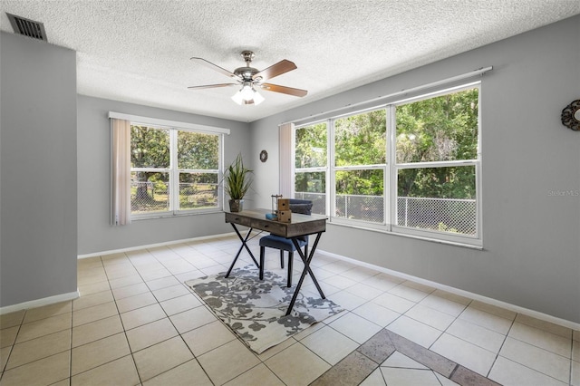 unfurnished office featuring ceiling fan, light tile patterned floors, and a textured ceiling