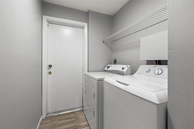 laundry area with dark hardwood / wood-style flooring and separate washer and dryer