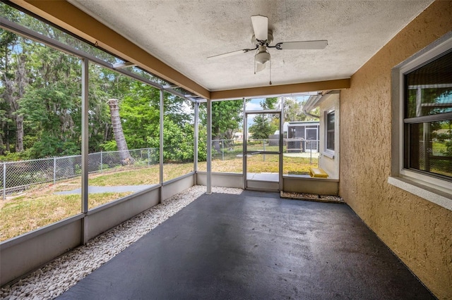 unfurnished sunroom featuring ceiling fan and a healthy amount of sunlight