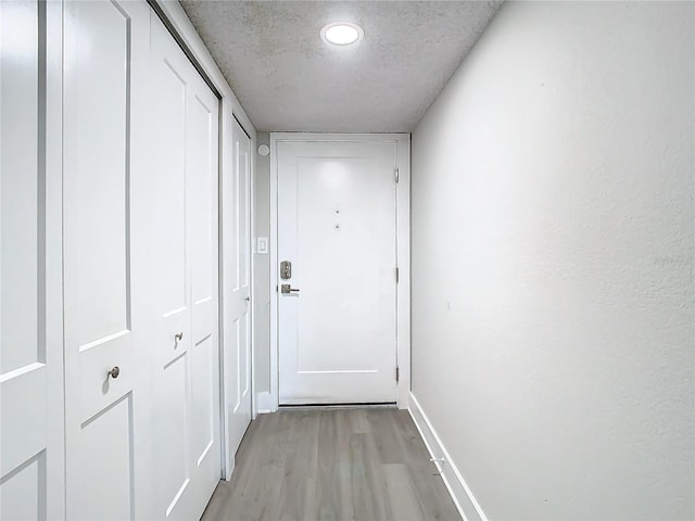 400 Island Way Unit 1411, Clearwater Beach, FL 33767 - doorway to outside with light wood-style floors, baseboards, and a textured ceiling
