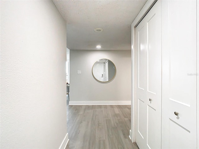 400 Island Way Unit 1411, Clearwater Beach, FL 33767 - hall with baseboards, light wood-style flooring, and a textured ceiling
