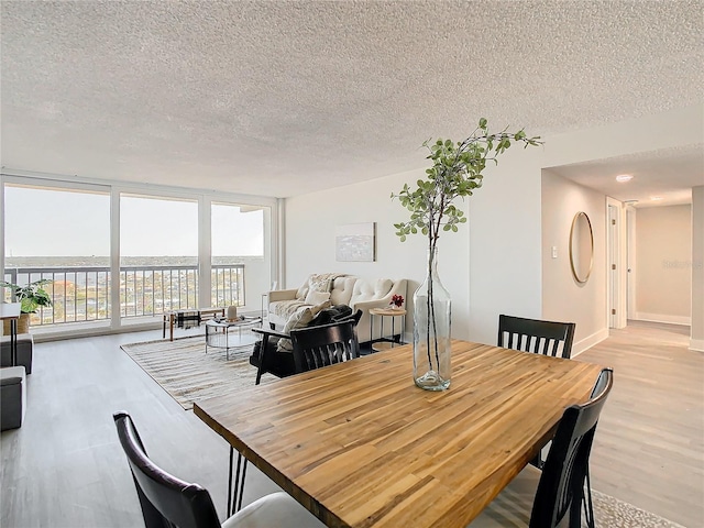 dining space featuring light hardwood / wood-style floors and a textured ceiling