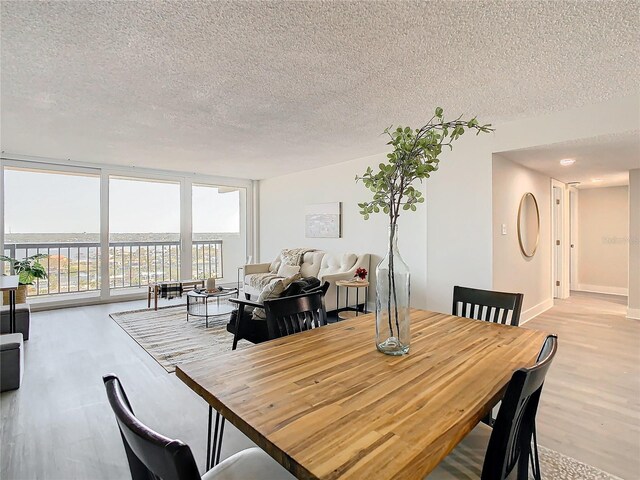 400 Island Way Unit 1411, Clearwater Beach, FL 33767 - dining room featuring wood finished floors, a textured ceiling, and a wall of windows